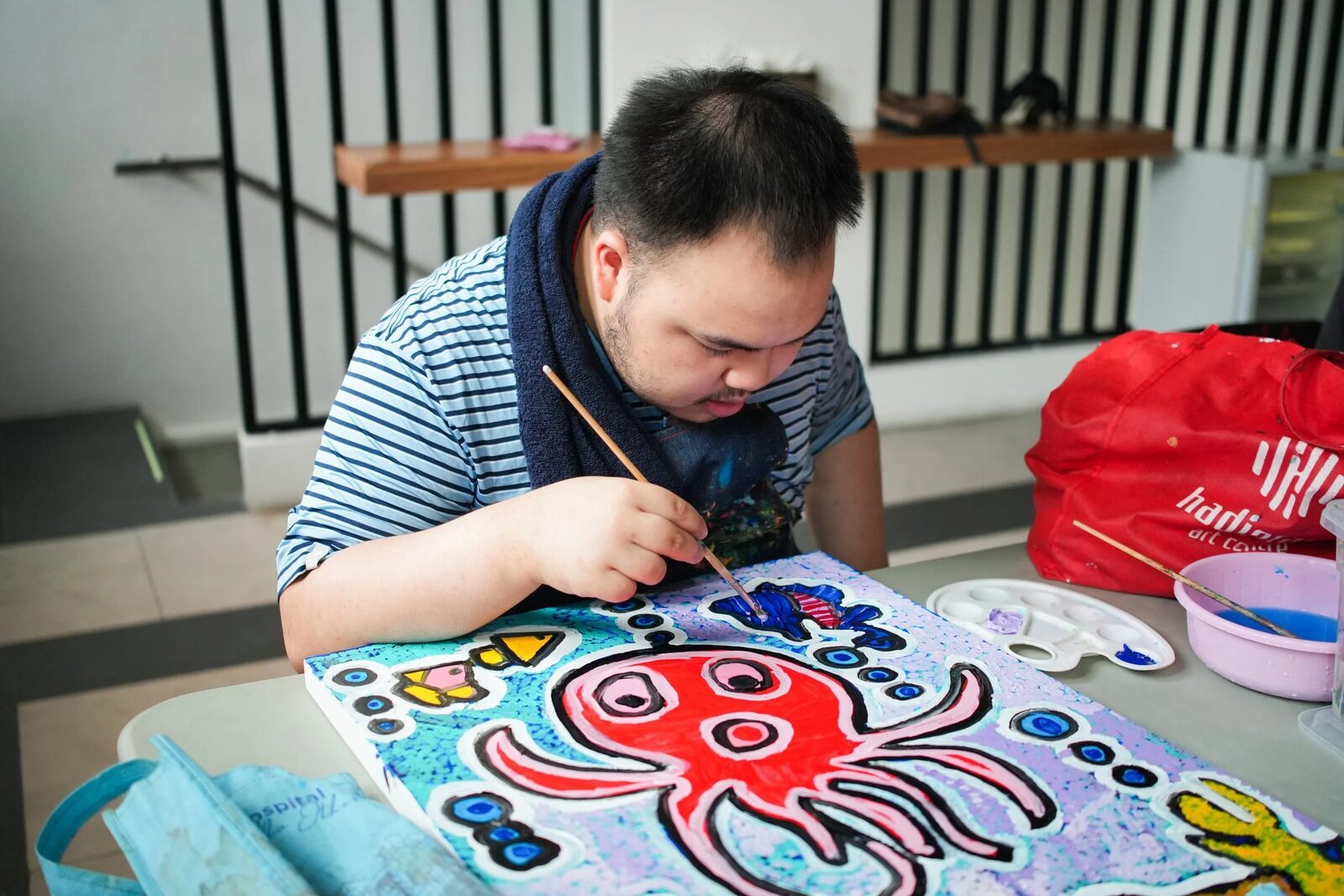 A mentor supporting a participant in art class